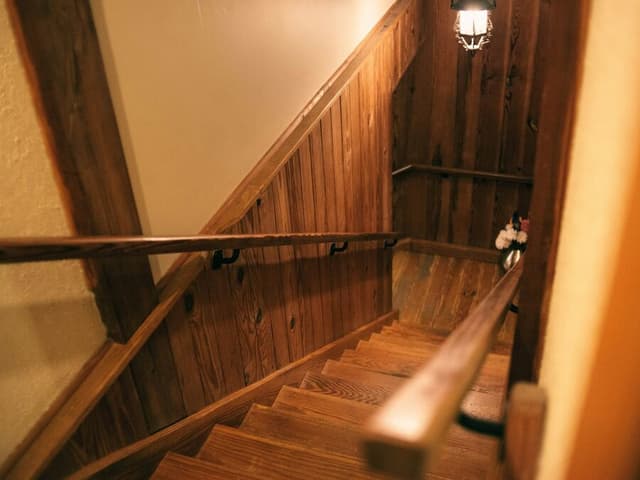 Un escalier de bois et sa main courante, vus du palier